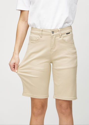 Modellen strekker shortsen ved låret for å vise stretch.