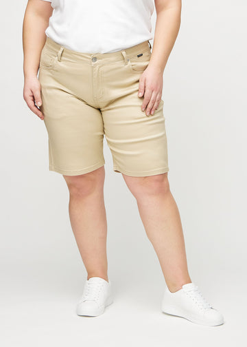 Beige regular middle shorts, modellnavn Gazelles, som går rett ned langs benet og slutter rett over kneet på en plus-size-modell, sett forfra.