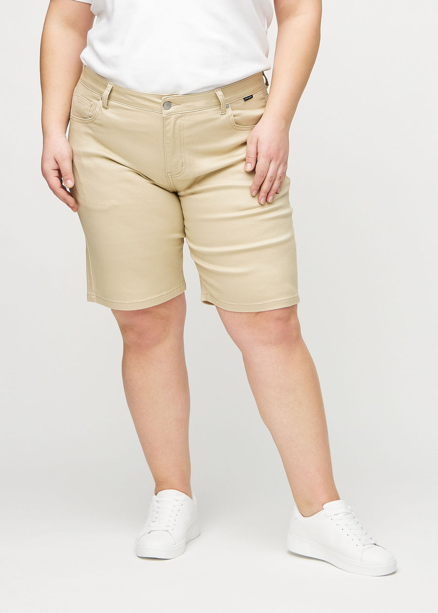 Beige regular middle shorts, modellnavn Gazelles, som går rett ned langs benet og slutter rett over kneet på en plus-size-modell, sett forfra.