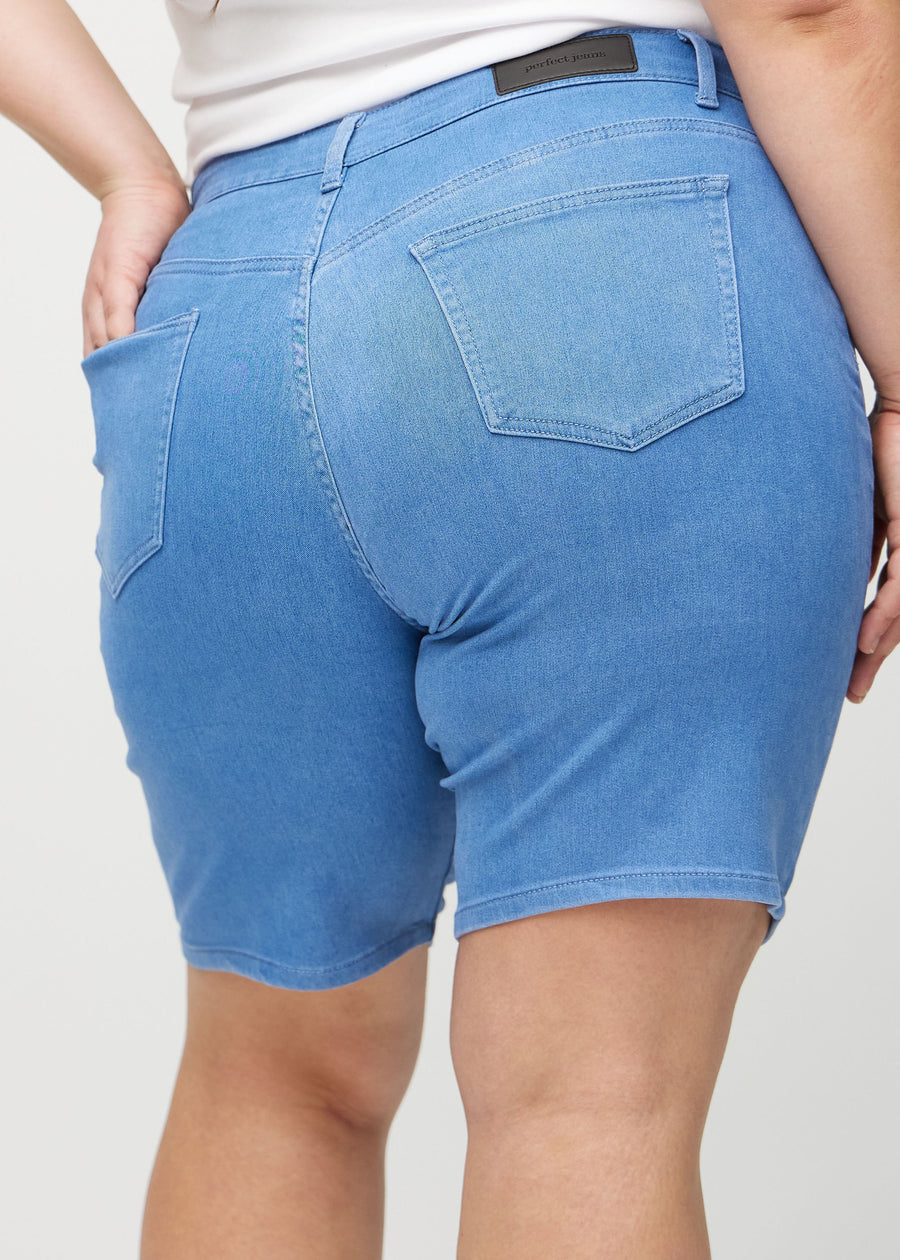 Blå regular middle shorts sett bakfra på nært hold på en plus-size modell for å vise detaljer.