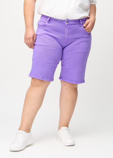 Lilla regular middle shorts, modellnavn Lavenders, som går rett ned langs benet og slutter rett over kneet på en plus-size-modell, sett forfra.