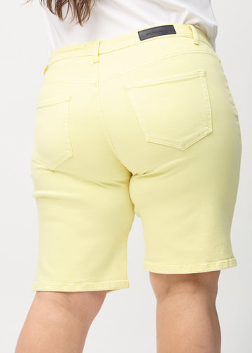 Lysegule regular middle shorts sett bakfra på nært hold på en plus-size-modell for å vise detaljer.