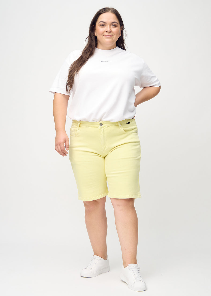 Fullt bilde av en plus-size-modell i lysegule regular middle shorts.