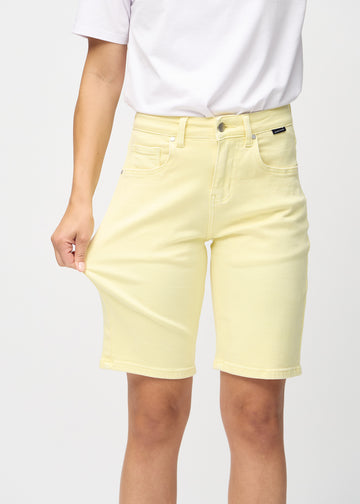 Modellen strekker shortsen ved låret for å vise stretch.
