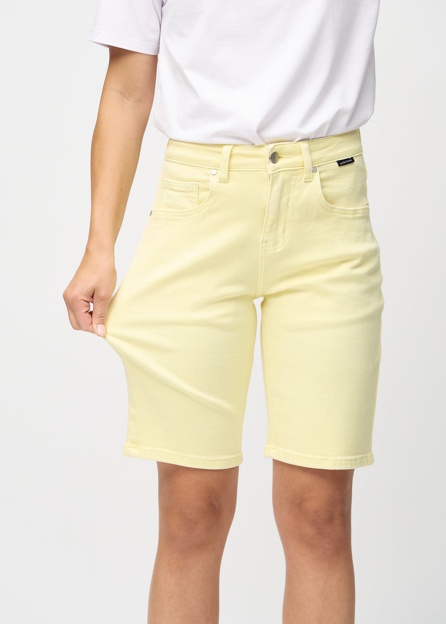 Modellen strekker shortsen ved låret for å vise stretch.