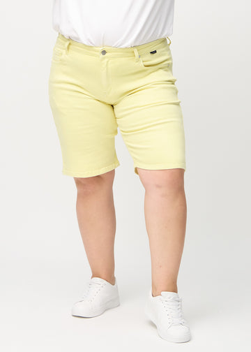 Lysegule regular middle shorts, modellnavn Lemonades, som går rett ned langs benet og slutter rett over kneet på en plus-size-modell, sett forfra.

