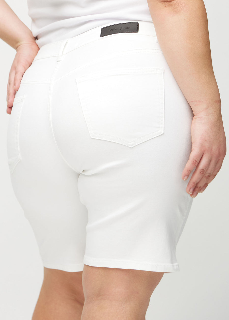 Hvite regular middle shorts sett bakfra på nært hold på en plus-size modell for å vise detaljer.
