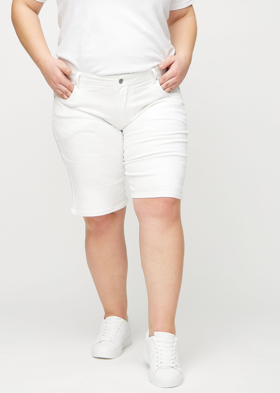 Hvite regular middle shorts, modellnavn Marguerites, som går rett ned langs benet og slutter rett over kneet på en plus-size modell, sett forfra.