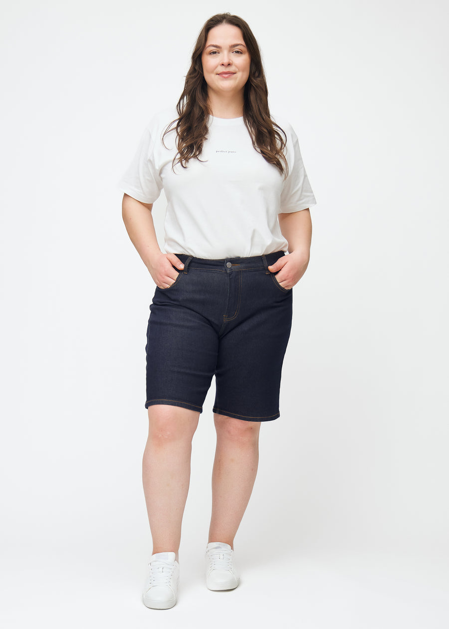 Helbilde av plus-size modell i dyp mørkeblå denimshorts til dame i fargen Midnights med regular passform.