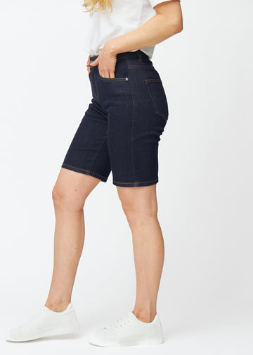 Dyp mørkeblå denimshorts til dame i fargen Midnights med regular passform sett fra siden på modell.