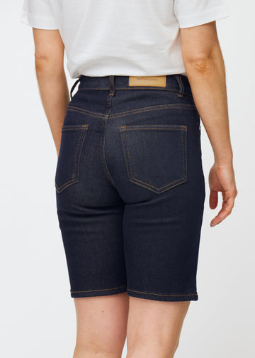 Dyp mørkeblå denimshorts til dame i fargen Midnights sett bakfra i nærbilde for å vise passform og detaljer.