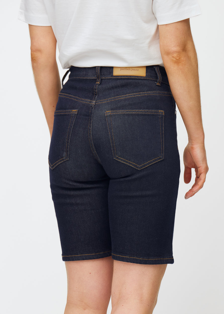 Dyp mørkeblå denimshorts til dame i fargen Midnights sett bakfra i nærbilde for å vise passform og detaljer.