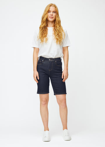 Helbilde av modell i dyp mørkeblå denimshorts til dame i fargen Midnights med regular passform.