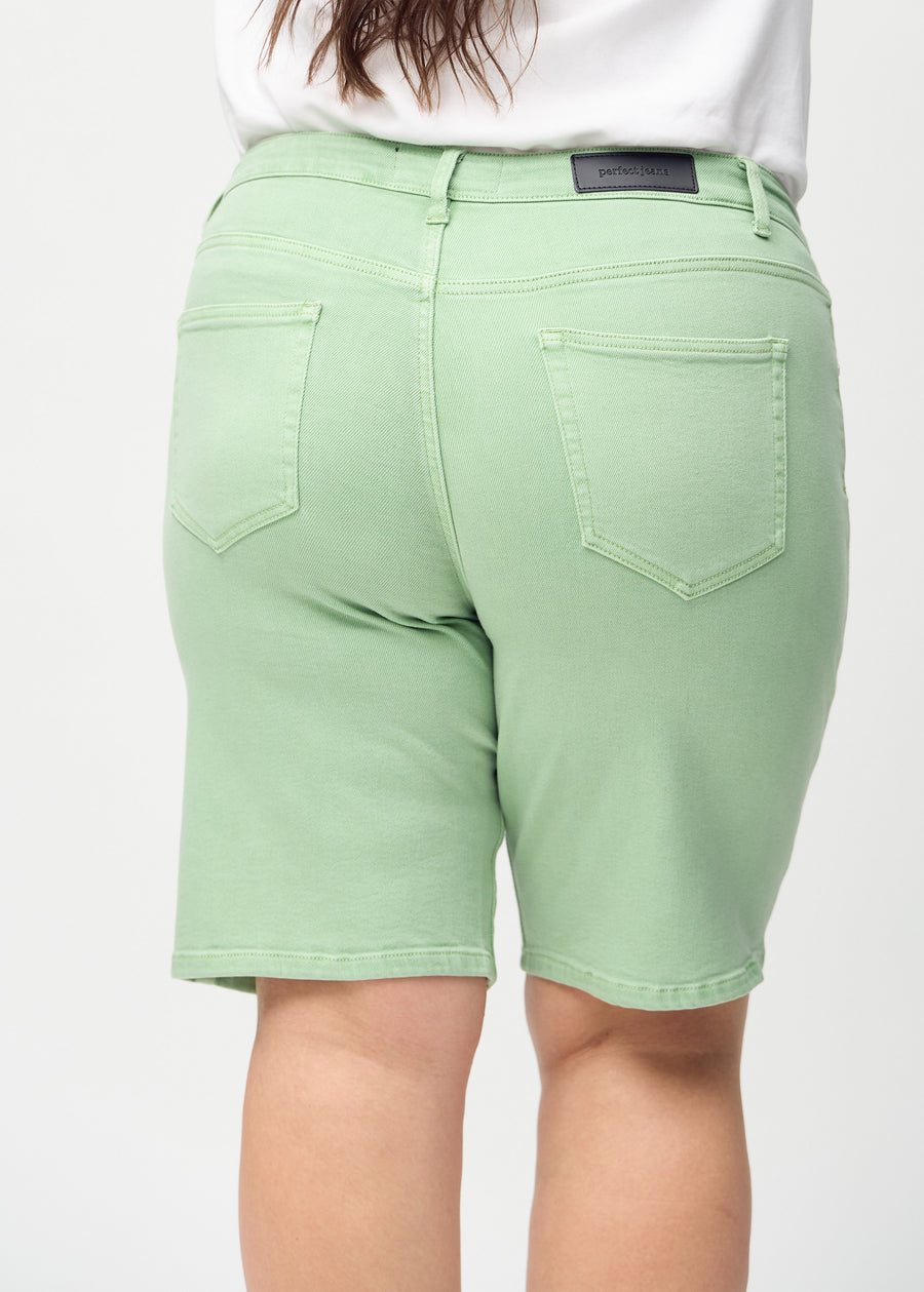 Lysegrønne regular middle shorts sett bakfra på nært hold på en plus-size modell for å vise detaljer.