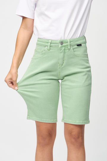 Modellen strekker shortsen ved låret for å vise stretch.
