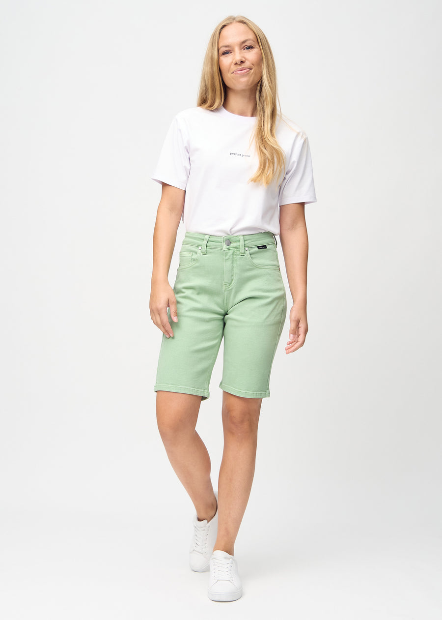 Fullt bilde av modell i lysegrønne regular middle shorts.