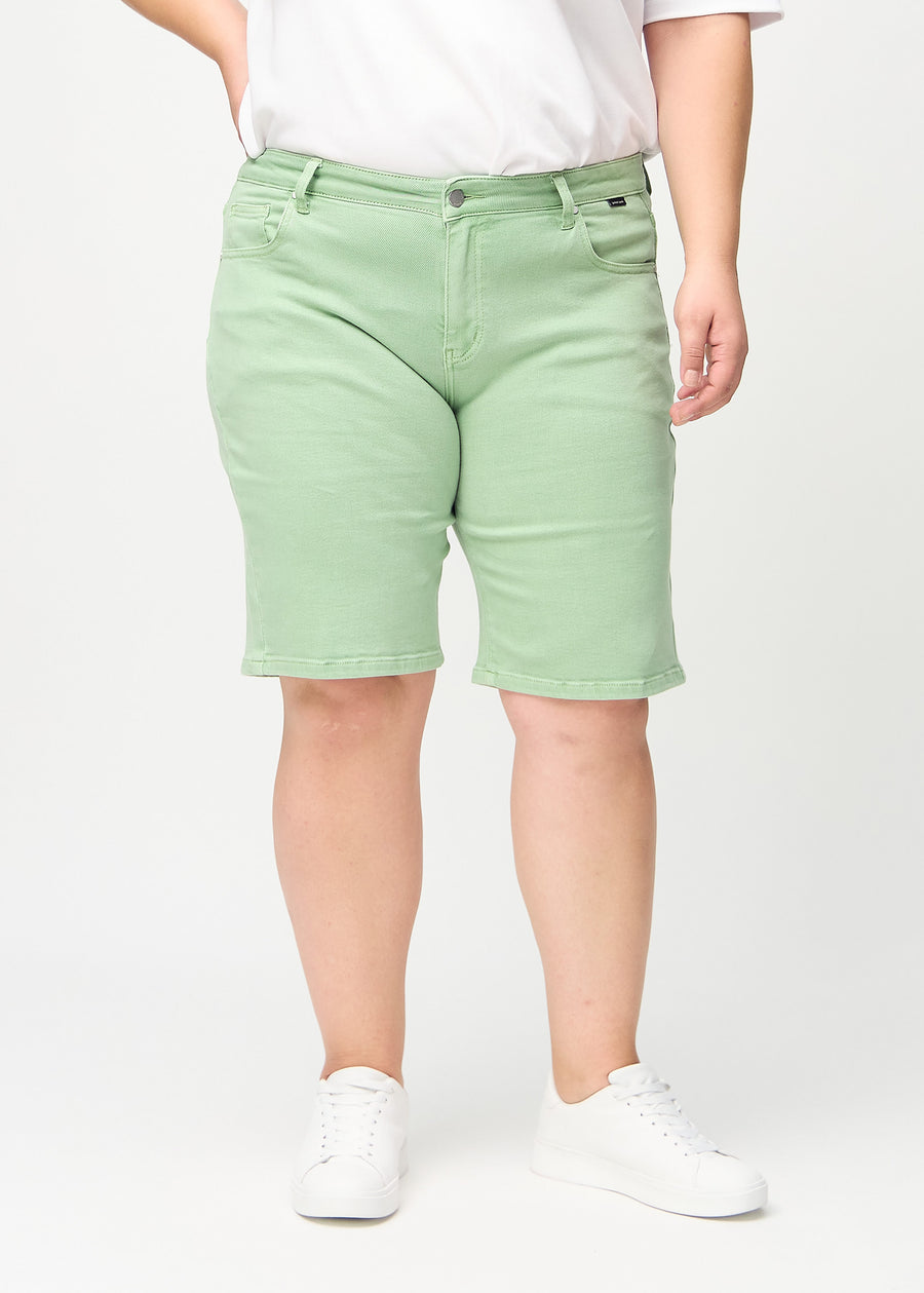 Lysegrønne regular middle shorts, modellnavn Mints, som går rett ned langs benet og slutter rett over kneet på en plus-size modell, sett forfra.