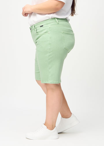 Lysegrønne regular middle shorts sett fra siden på en plus-size modell.