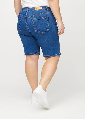Mørk denim regular middle shorts sett bakfra på en plus-size modell, så man kan se hele produktet.