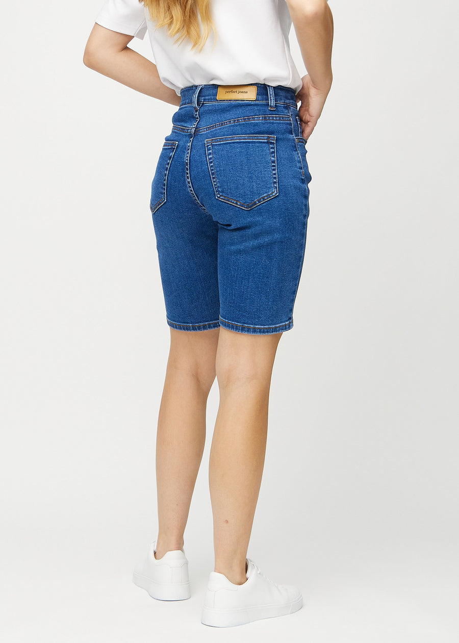 Mørk denim regular middle shorts sett fra siden på modell.