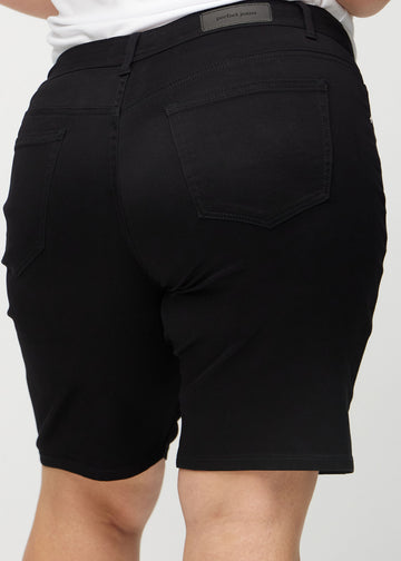 Svarte regular middle shorts sett bakfra på nært hold på en plus-size modell for å vise detaljer.