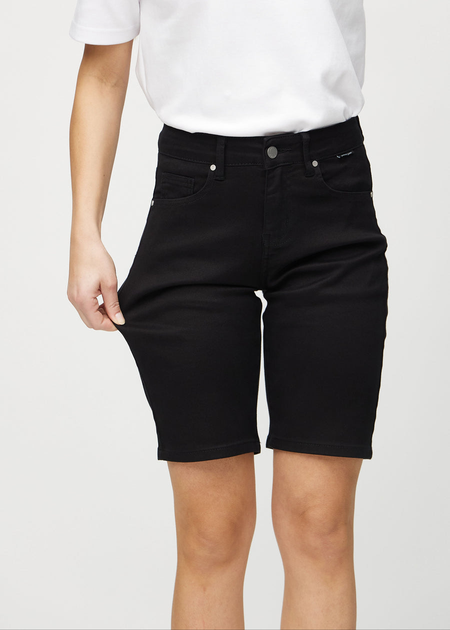 Modellen strekker shortsen ved låret for å vise stretch.