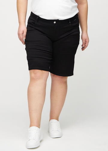 Svarte regular middle shorts, modellnavn Ravens, som går rett ned langs benet og slutter rett over kneet på en plus-size modell, sett forfra.