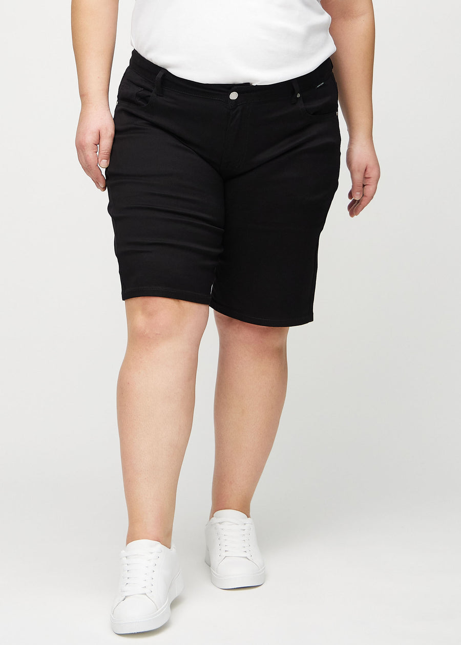 Svarte regular middle shorts, modellnavn Ravens, som går rett ned langs benet og slutter rett over kneet på en plus-size modell, sett forfra.