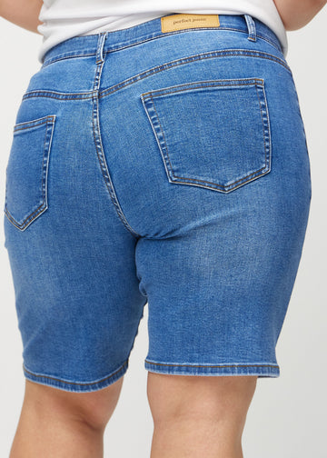Denim regular middle shorts sett bakfra på nært hold på en plus-size-modell for å vise detaljer.