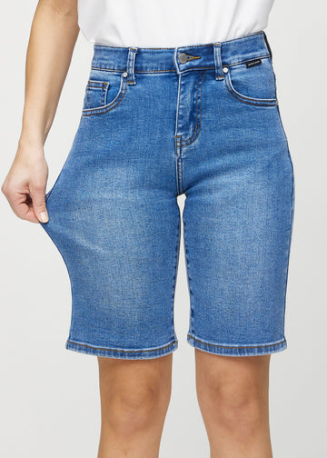 Modellen strekker shortsen ved låret for å vise stretch.