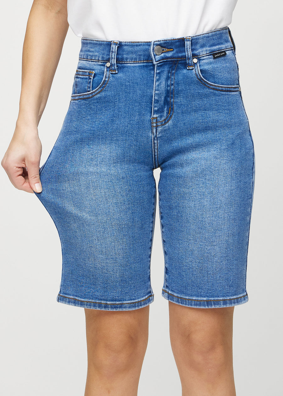 Modellen strekker shortsen ved låret for å vise stretch.