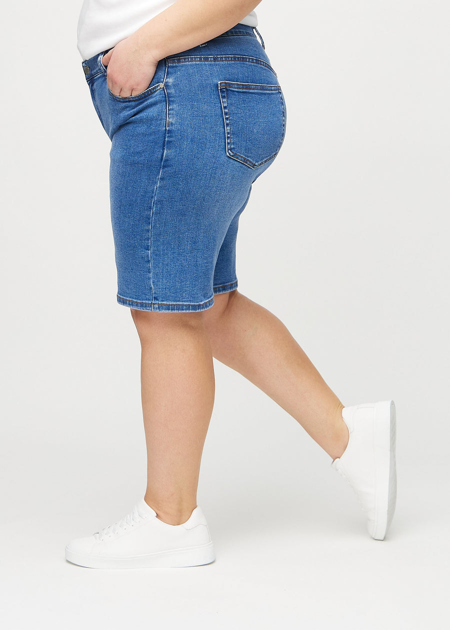 Denim regular middle shorts sett fra siden på en plus-size-modell.