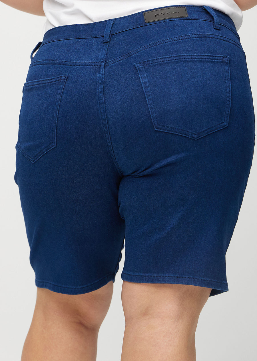 Mørkeblå regular middle shorts sett bakfra på nært hold på en plus-size modell for å vise detaljer.