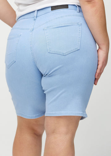 Lysblå regular middle shorts sett bakfra på nært hold på en plus-size-modell for å vise detaljer.