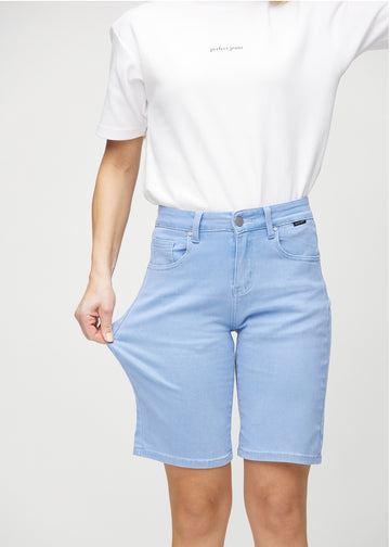 Modellen strekker shortsen ved låret for å vise stretch.