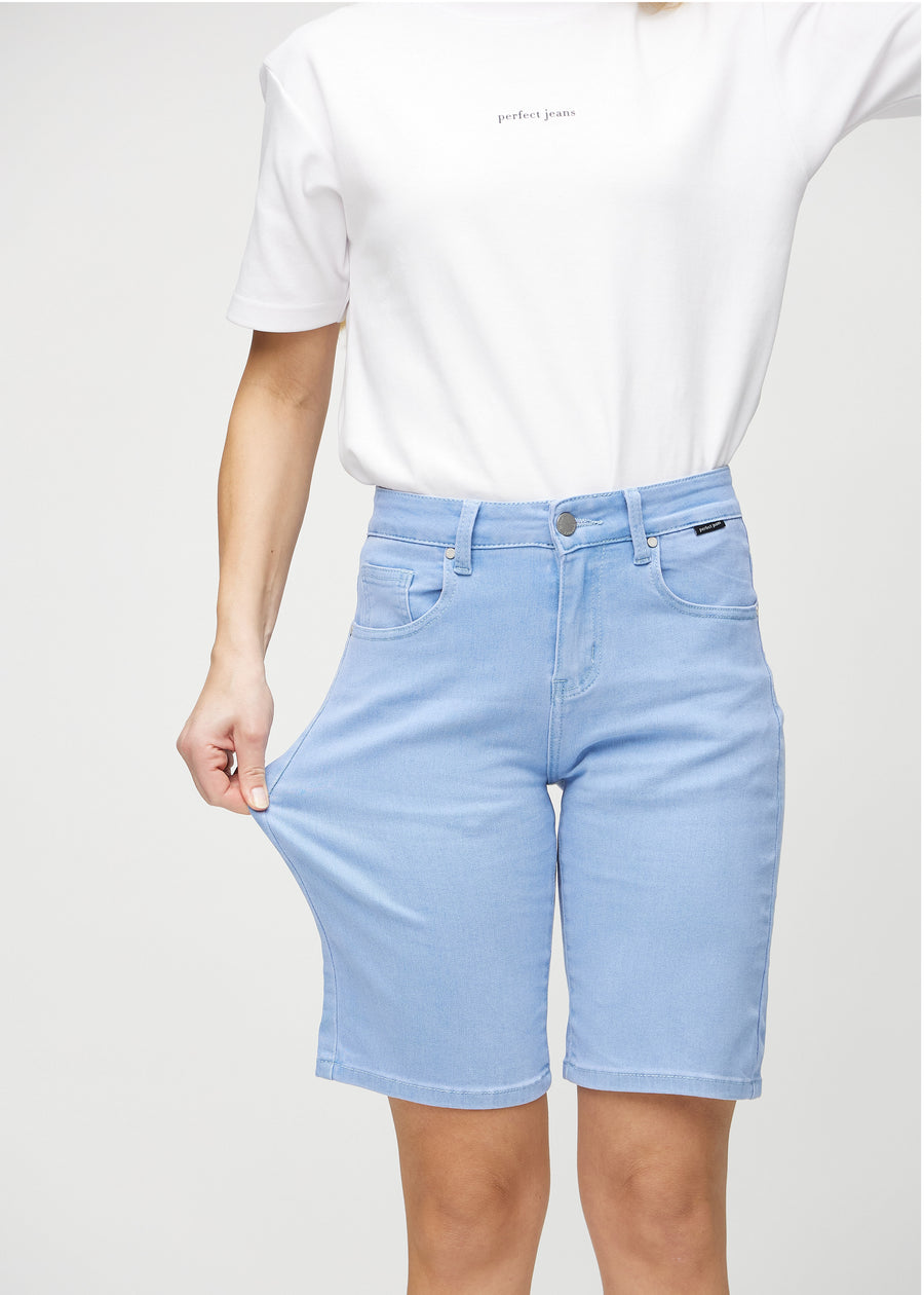Modellen strekker shortsen ved låret for å vise stretch.