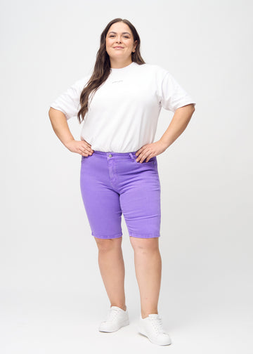 Fullt bilde av en plus-size-modell i lilla skinny middle shorts.