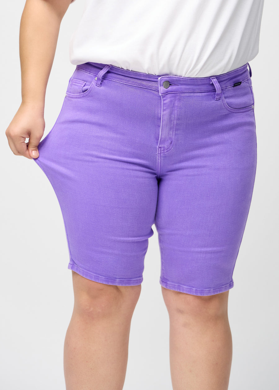 Plus-size-modellen strekker shortsene ved låret for å vise stretch.