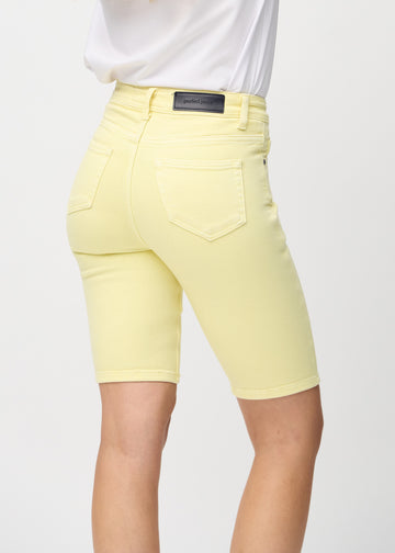 Lysegule skinny middle shorts sett bakfra på nært hold for å vise detaljer.