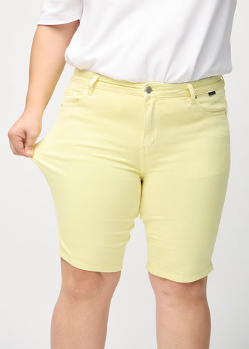 Plus-size-modellen strekker shortsene ved låret for å vise stretch.