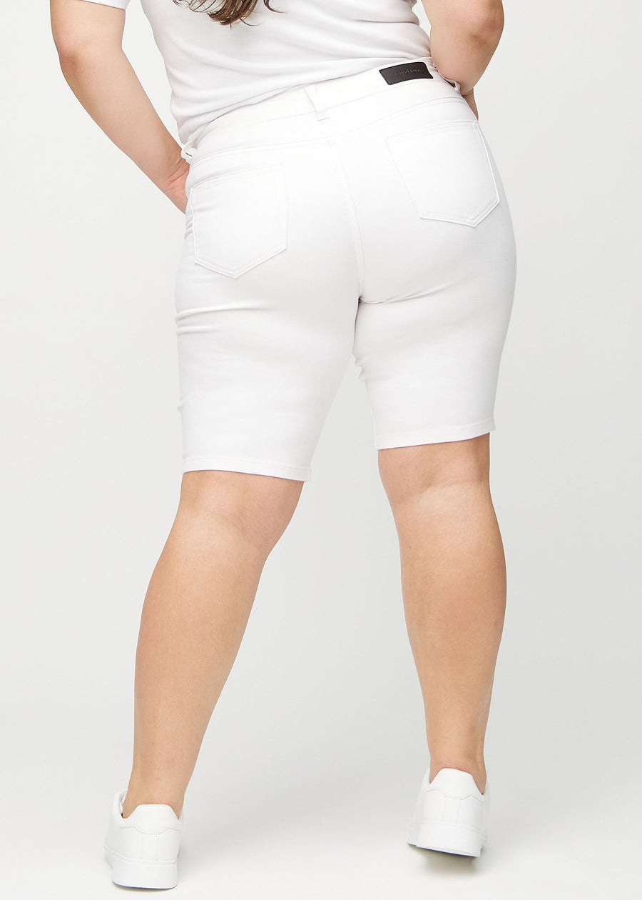 Hvite skinny middle shorts sett bakfra på en plus-size-modell, slik at man kan se hele produktet.