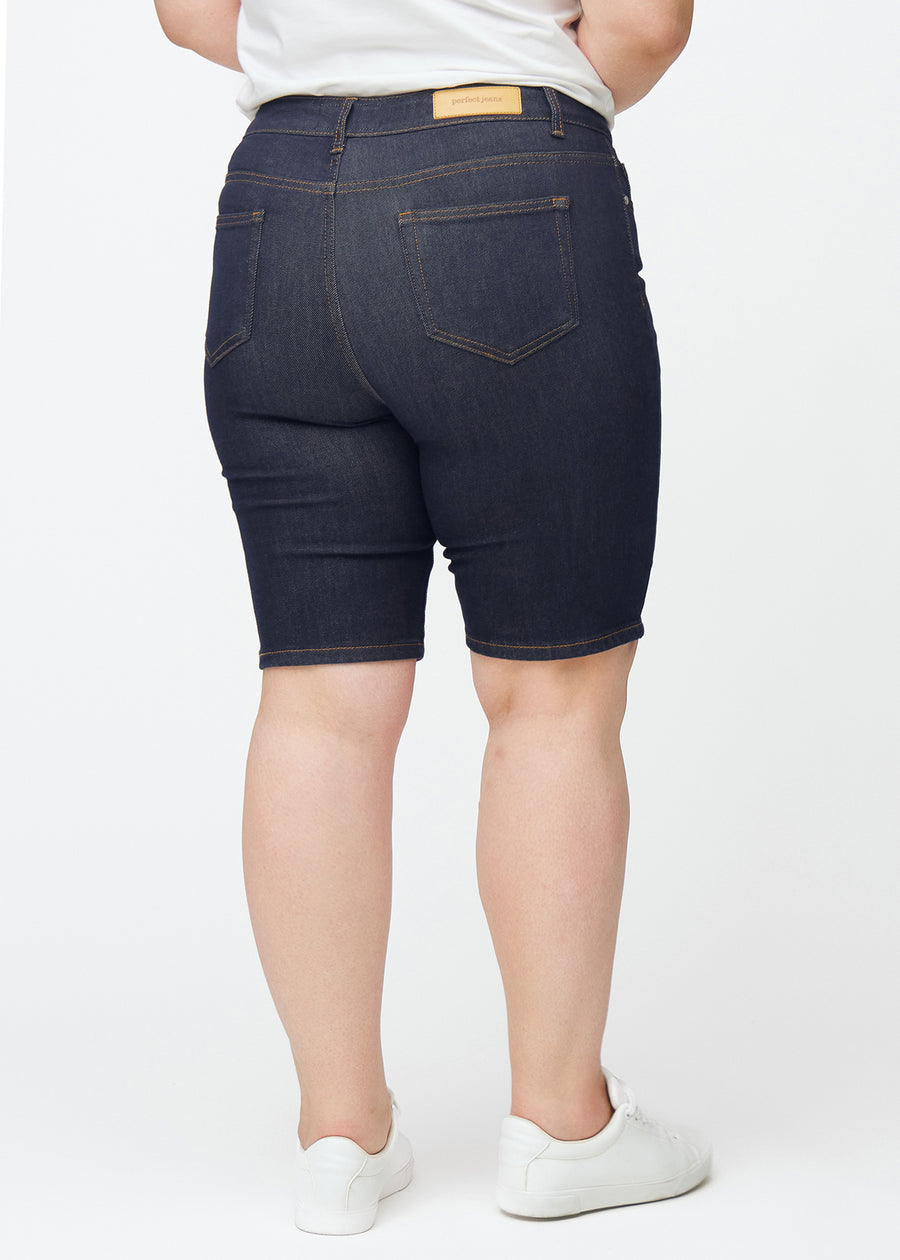 Dyp mørkeblå denimshorts til dame i fargen Midnights sett bakfra på plus-size modell.