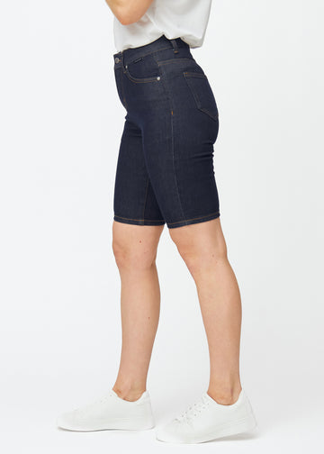 Dyp mørkeblå denimshorts til dame i fargen Midnights med skinny passform sett fra siden på modell.