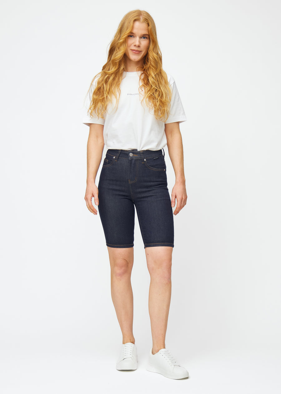 Helbilde av modell i dyp mørkeblå denimshorts til dame i fargen Midnights med skinny passform.
