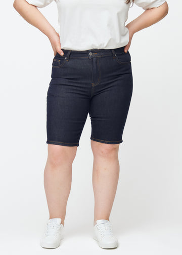 Dyp mørkeblå denimshorts til dame i fargen Midnights med skinny passform sett forfra på plus-size modell.