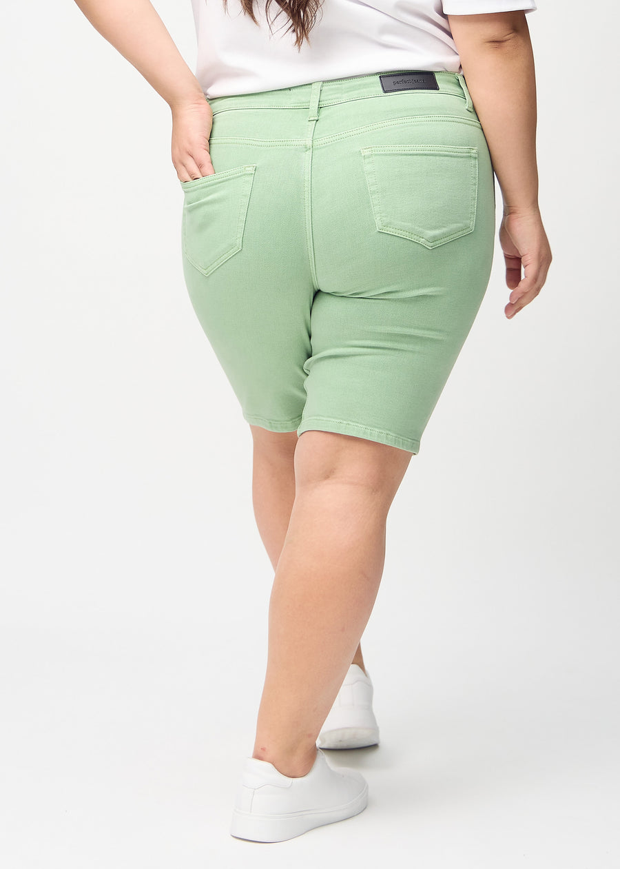 Lysegrønne skinny middle shorts sett bakfra på en plus-size-modell, slik at man kan se hele produktet.