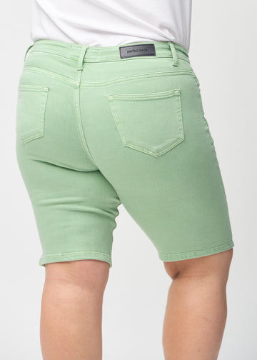 Lysegrønne skinny middle shorts sett bakfra på nært hold på en plus-size-modell for å vise detaljer.