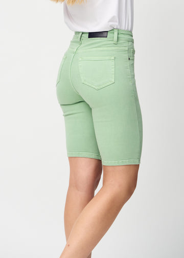 Lysegrønne skinny middle shorts sett bakfra på nært hold for å vise detaljer.