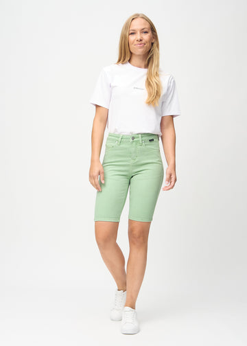 Fullt bilde av modell i lysegrønne skinny middle shorts.