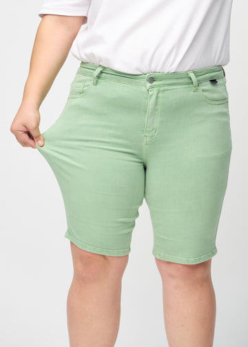 Plus-size-modellen strekker shortsene ved låret for å vise stretch.